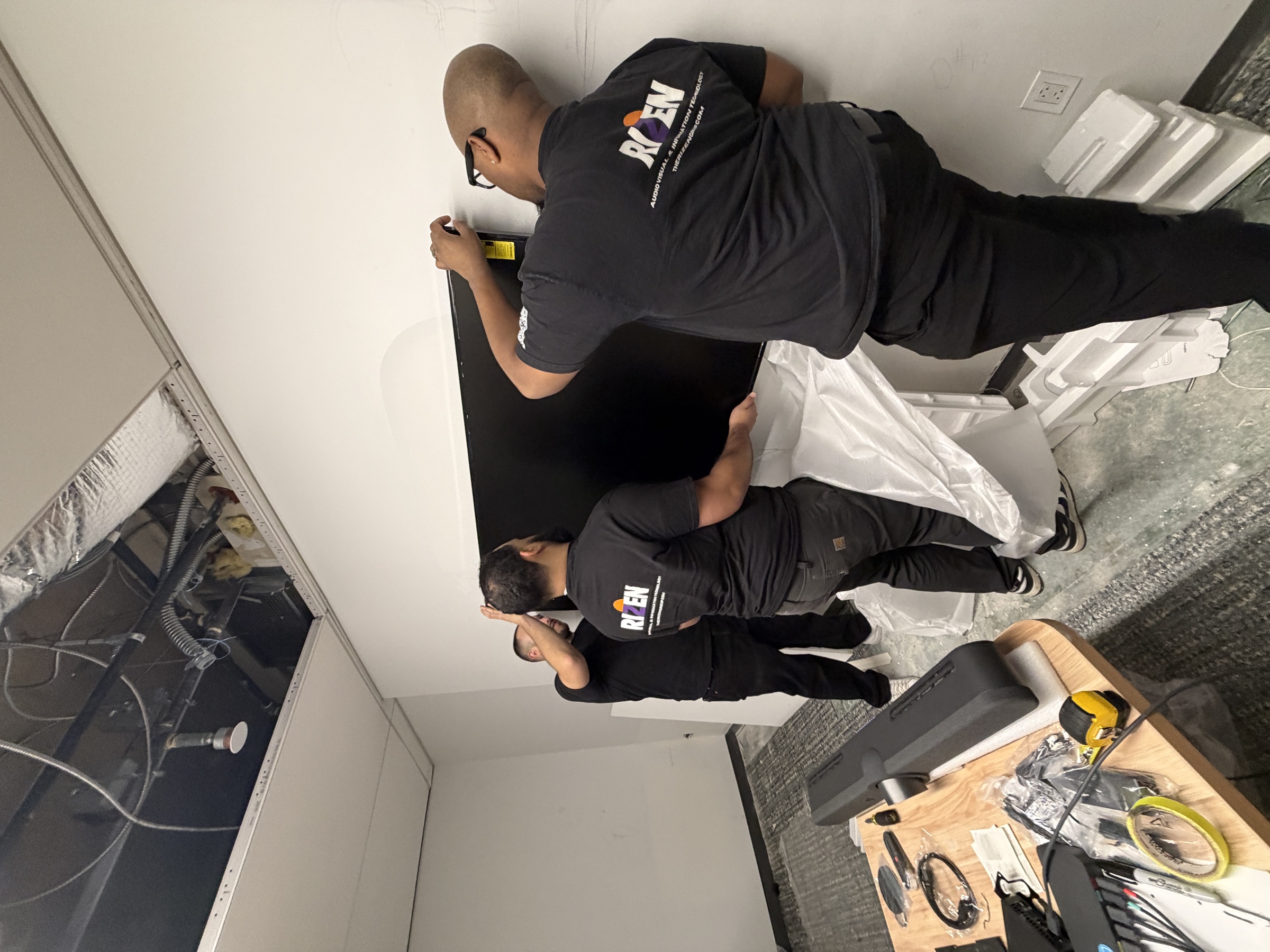 The Rizen team mounting a Samsung Frame TV in a private office