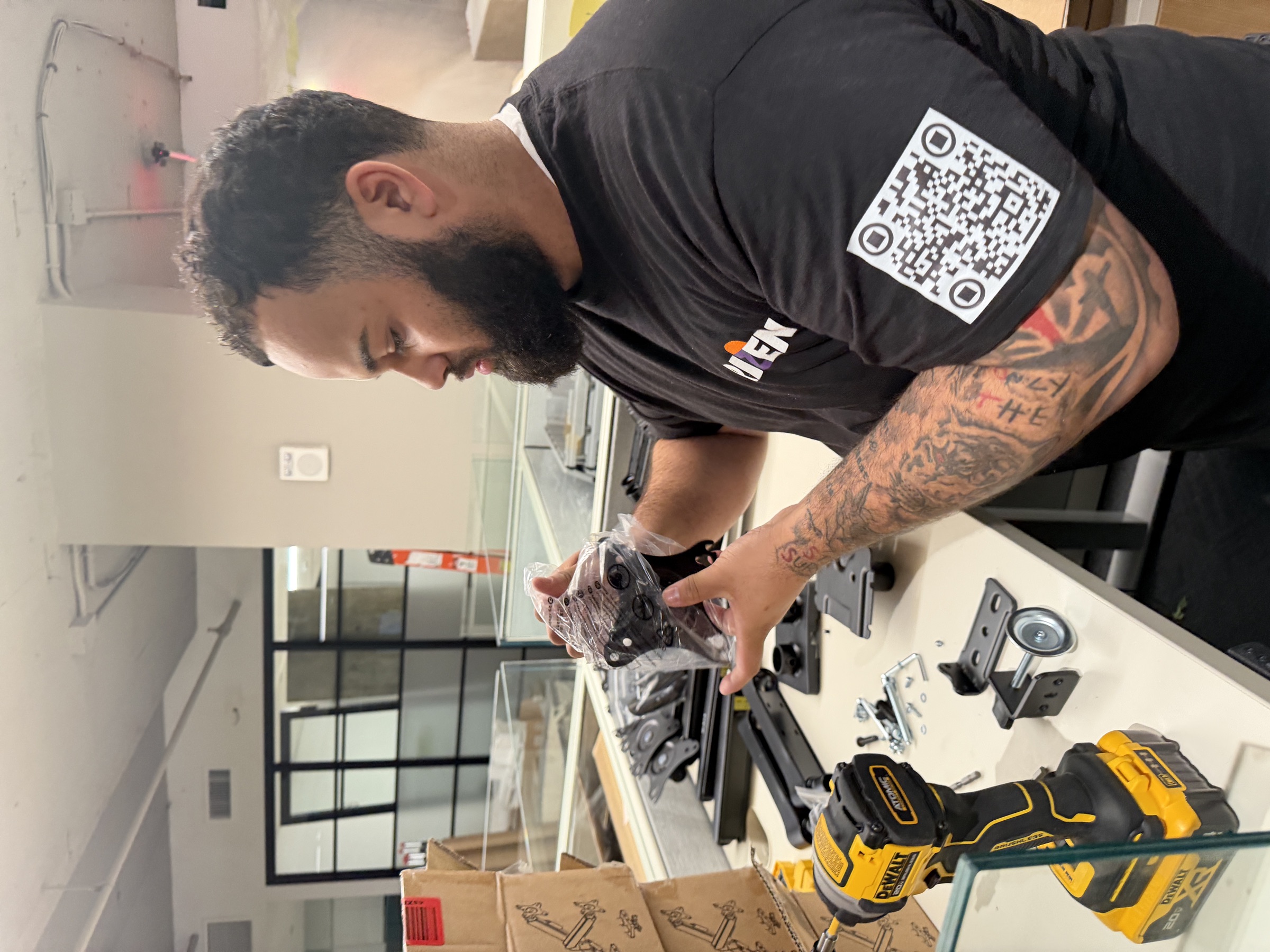A Rizen technician preparing display mounting hardware at the TCG office